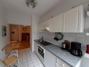 a kitchen with white cabinets and a counter top at Kleine Altstadt-Wohnung mit Terrasse in Wismar