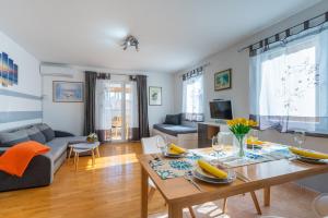 a living room with a table and a couch at Apartment Kristian in Cres