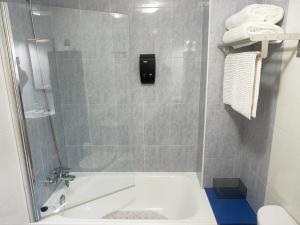 y baño con ducha, bañera y lavamanos. en Apartamento O SALEIRO, en Padrón