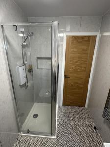 a shower with a glass door in a bathroom at Royal Oak Guesthouse in Orkney
