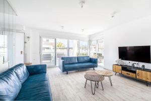 sala de estar con sofá azul y TV en Casa Bos Orange Wellness Luxury Entire Villa Jacuzzi & Pool Gran Alacant near Beach, en Puerto Marino