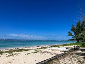 a boat sitting on a beach next to the ocean at Belle Mare 3 bedroom Luxury villa 6 on a blue ocean in Palmar