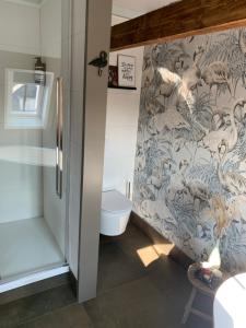 een badkamer met een douche en een muurschildering van vogels bij Bed and Breakfast Geliefd in Voorhout