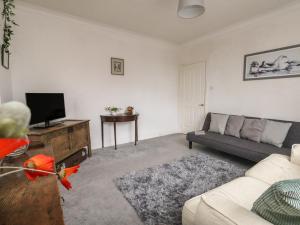 a living room with a couch and a tv at Victoria Court in Weymouth