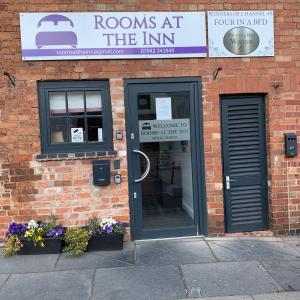 een bakstenen gebouw met een deur en bloemen voor de deur bij Rooms at the Inn in Retford