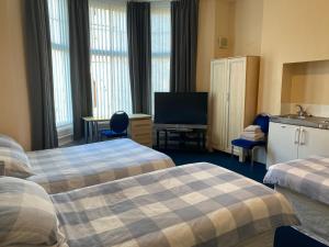 a hotel room with two beds and a flat screen tv at Athol House in South Shields