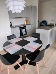 y cocina con mesa de comedor y sillas. en Ny bolig i grønne omgivelser., en Rødovre