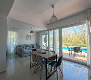 a living room with a table and chairs and a couch at Villa Meltemi in Daratso