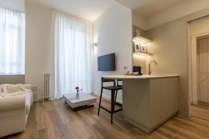 cocina y sala de estar con mesa y sofá en BePlace Apartments in De Angeli, en Milán