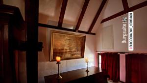 ein Zimmer mit einem Gemälde an der Wand und zwei Kerzen in der Unterkunft Burg Zimmer auf ca. 70 m² in Heimbach