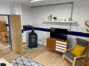 a living room with a tv and a wood stove at Ubytování Česká Kanada in Kunžak