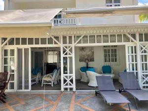 a patio with chairs and tables on a house at Belle Mare 3 bedroom Luxury villa 6 on a blue ocean in Palmar