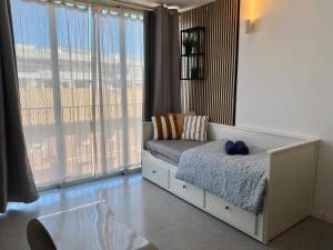 a bedroom with a bed and a large window at Acogedor Apartamento in Valencia