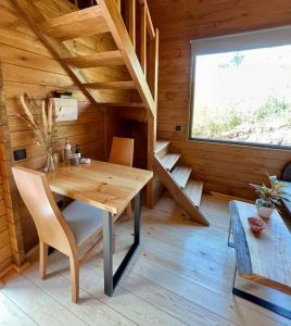 Habitación de madera con mesa y sillas en una cabaña en Mountain Eco Shelter 8 en Funchal
