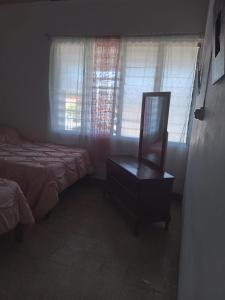 a bedroom with a bed and a dresser and a mirror at Belretiro Cottage in Ocho Rios