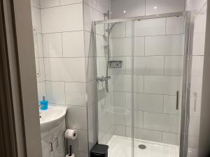 a white bathroom with a shower and a sink at Athol House in South Shields