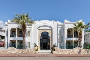 凱梅爾的住宿－Perlo Hotel Kemer，一座白色的建筑,前面有棕榈树