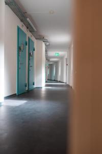 an empty hallway with blue doors in an empty room at Bogentrakt in Chur