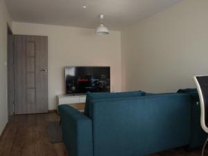 sala de estar con sofá azul y TV en Apartament Gdańsk Stogi Plaża en Gdansk
