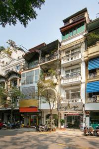 un edificio blanco alto con balcones en una calle en Hanoi Moonlight Hotel, en Hanói