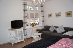 uma sala de estar com um sofá e uma televisão em Landhaus Eickhof em Niederhaverbeck