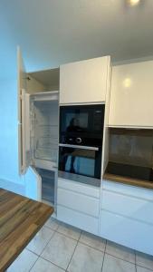 a kitchen with white cabinets and a microwave at Porte de Saint Émilion in Coutras