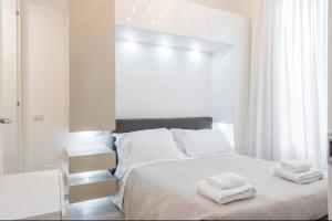 ein weißes Schlafzimmer mit 2 Handtüchern auf dem Bett in der Unterkunft Modern Apartment in Florence in Florenz