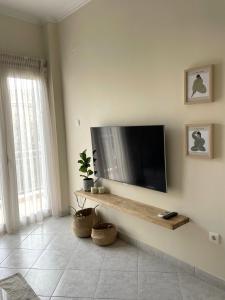 un soggiorno con TV a schermo piatto a parete di La bohème a Kiato