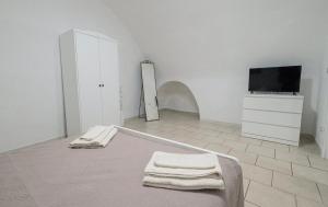 a white room with a bed and a tv at La casa di mammina in Bari