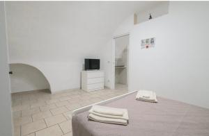 a white room with a bed with towels on it at La casa di mammina in Bari