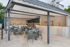 a restaurant with tables and chairs and a bar at Perlo Hotel Kemer in Kemer