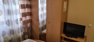 a room with a television and a window with a curtain at Vila Dubrovnik in Vrnjačka Banja