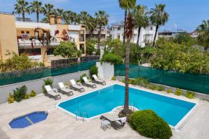 an overhead view of a swimming pool with lounge chairs and a palm tree at Perlo Hotel Kemer in Kemer