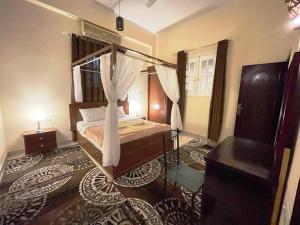 um quarto com uma cama de dossel num quarto em Happiness Guest House em Luxor