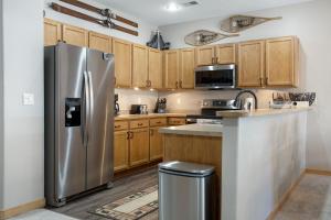 a kitchen with a stainless steel refrigerator and wooden cabinets at Canyon Run B203 condo in Avon