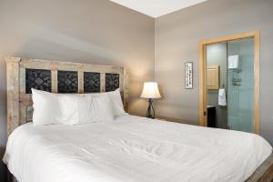 a bedroom with a large white bed and a shower at Canyon Run B203 condo in Avon +15 photos