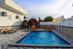 een zwembad aan de zijkant van een huis bij Happiness Guest House in Luxor
