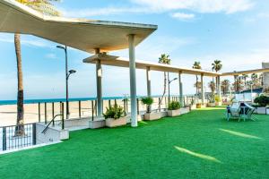 eine Terrasse mit grünem Gras und Strand in der Unterkunft Anka Beach Apartment Patacona in Valencia