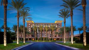 a building with palm trees in front of a road at The Westin Kierland Resort & Spa in Scottsdale