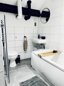 uma casa de banho com uma banheira, um WC e um lavatório. em EXCLUSIVE and MODERN - Bradford City Centre- 85" Cinema TV em Bradford