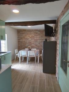 a kitchen and dining room with a table and a refrigerator at Hostel & Rooms Casa Maia in Padrón
