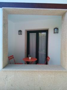 mesa y sillas en una habitación con ventana en Hostel & Rooms Casa Maia, en Padrón