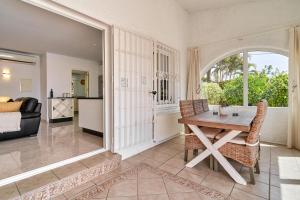 a dining room with a table and chairs and a living room at Casa Ambar in Nerja