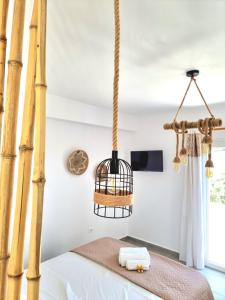 una camera con gabbia per uccelli appesa al soffitto di Joannes Vacation Rooms ad Adámas