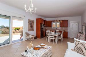 a kitchen and living room with a table and a dining room at Eleanna Eco House, Solar-Powered Home with Sea Views in Agios Pavlos