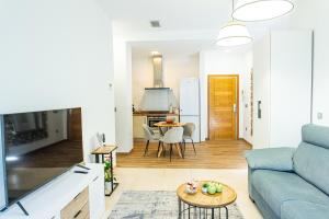 a living room with a blue couch and a table at Anka Beach Apartment Patacona in Valencia