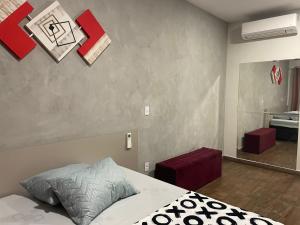 een slaapkamer met een bed en een spiegel bij Flat Aconchegante in Sorocaba