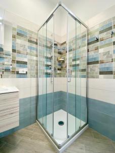 a shower with glass doors in a bathroom at Hostdomus - Bilocale da Patrizia in Finale Ligure