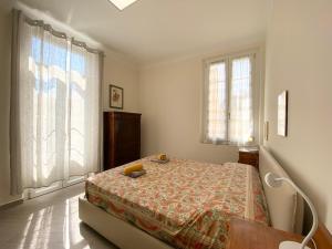 een slaapkamer met een bed en 2 ramen bij Hostdomus - Bilocale da Patrizia in Finale Ligure