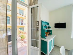 een kamer met een glazen schuifdeur en een televisie bij Hostdomus - Bilocale da Patrizia in Finale Ligure
